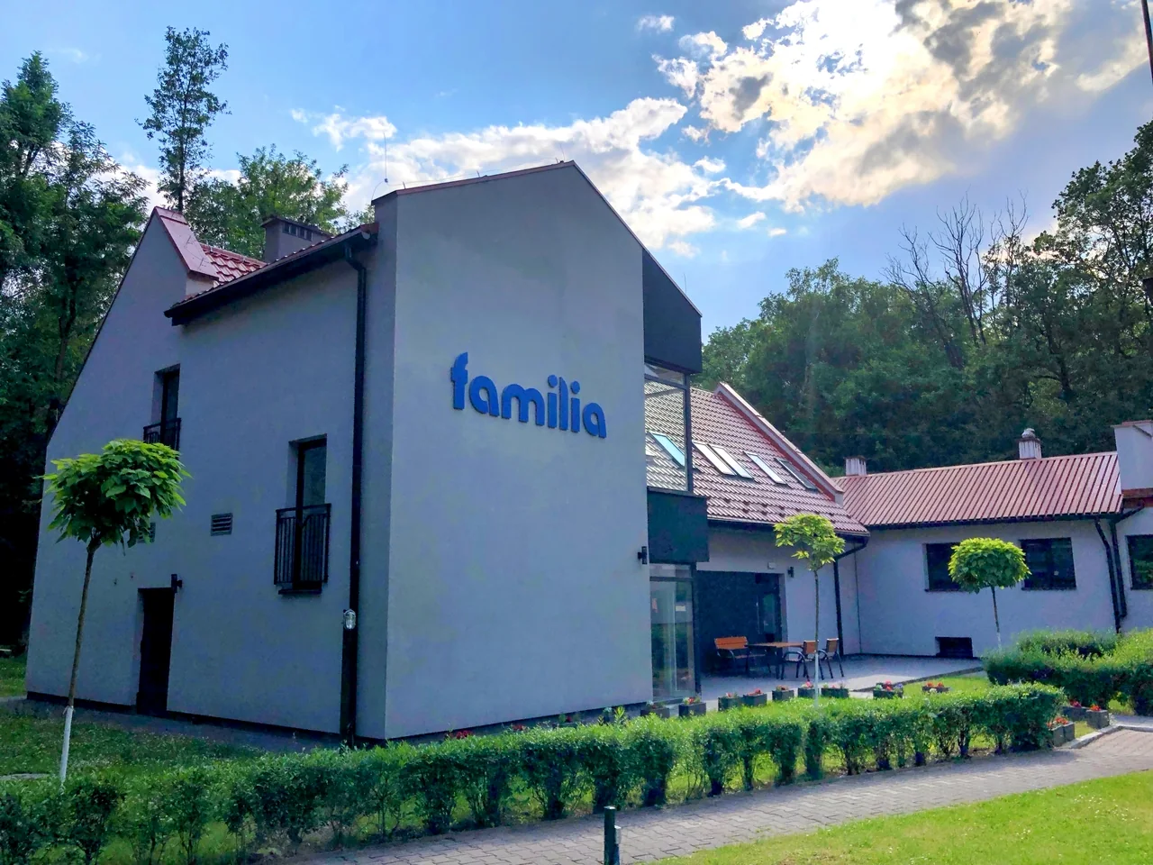 Budynek Centrum Leczenia Uzależnień Familia w Gliwicach, z napisem na elewacji i zielenią przed wejściem.