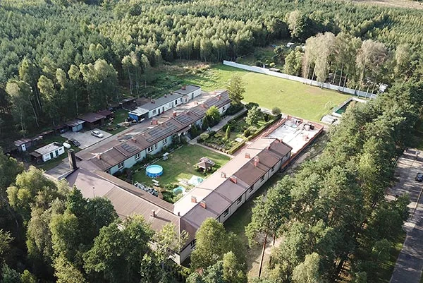 Ośrodek MONAR w Dębowcu widziany z góry, z budynkami, dziedzińcem i lasem wokół.