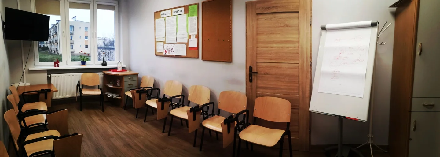 Sala oddziału dziennego WOTUW w Zielonej Górze, z krzesłami ustawionymi wokół pomieszczenia i flipchartem.