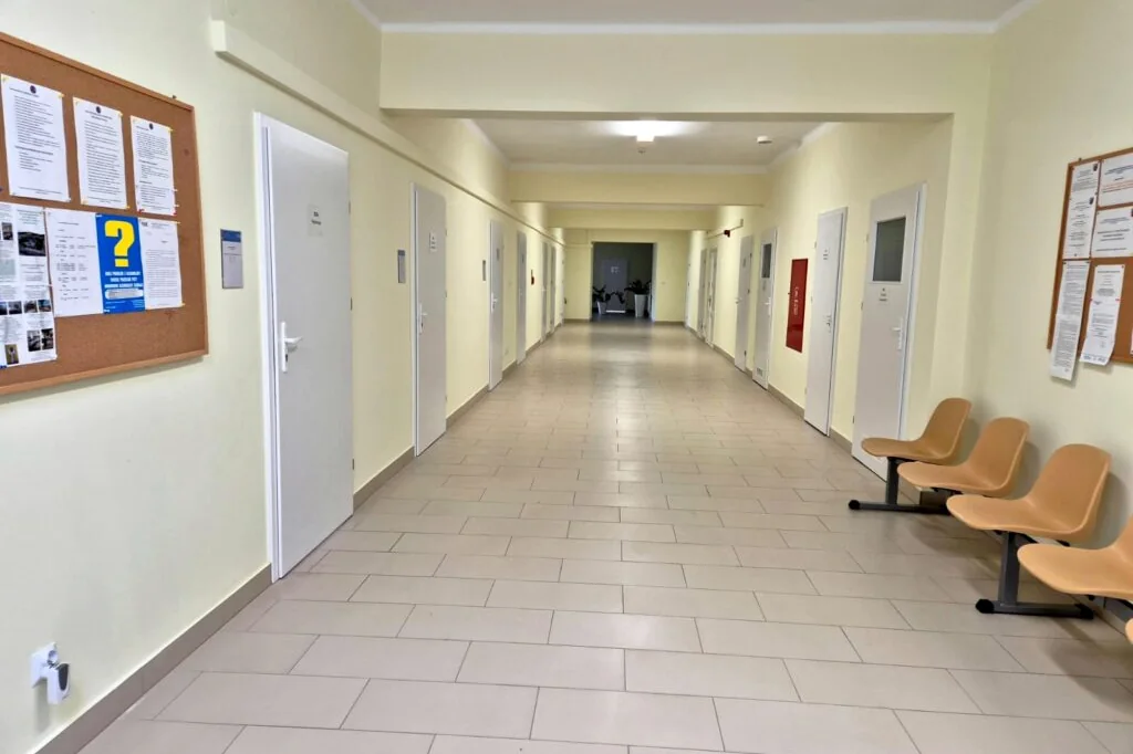 Korytarz Oddziału Dziennego Terapii Uzależnienia od Alkoholu w Przemyślu, z krzesłami przy gabinetach.