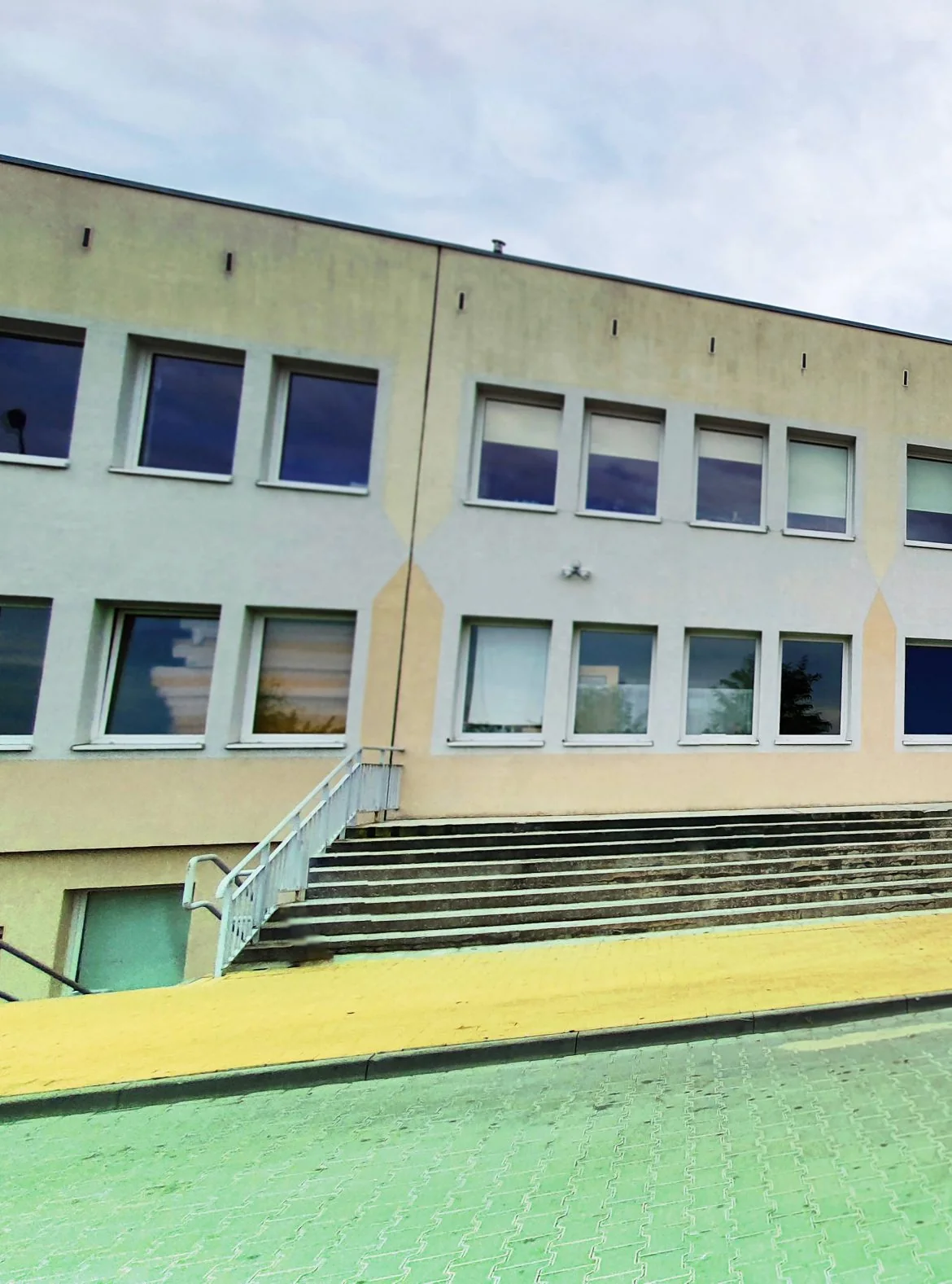 Fragment budynku Ośrodka Terapii Grunwald w Gubinie z jasną elewacją i schodami.