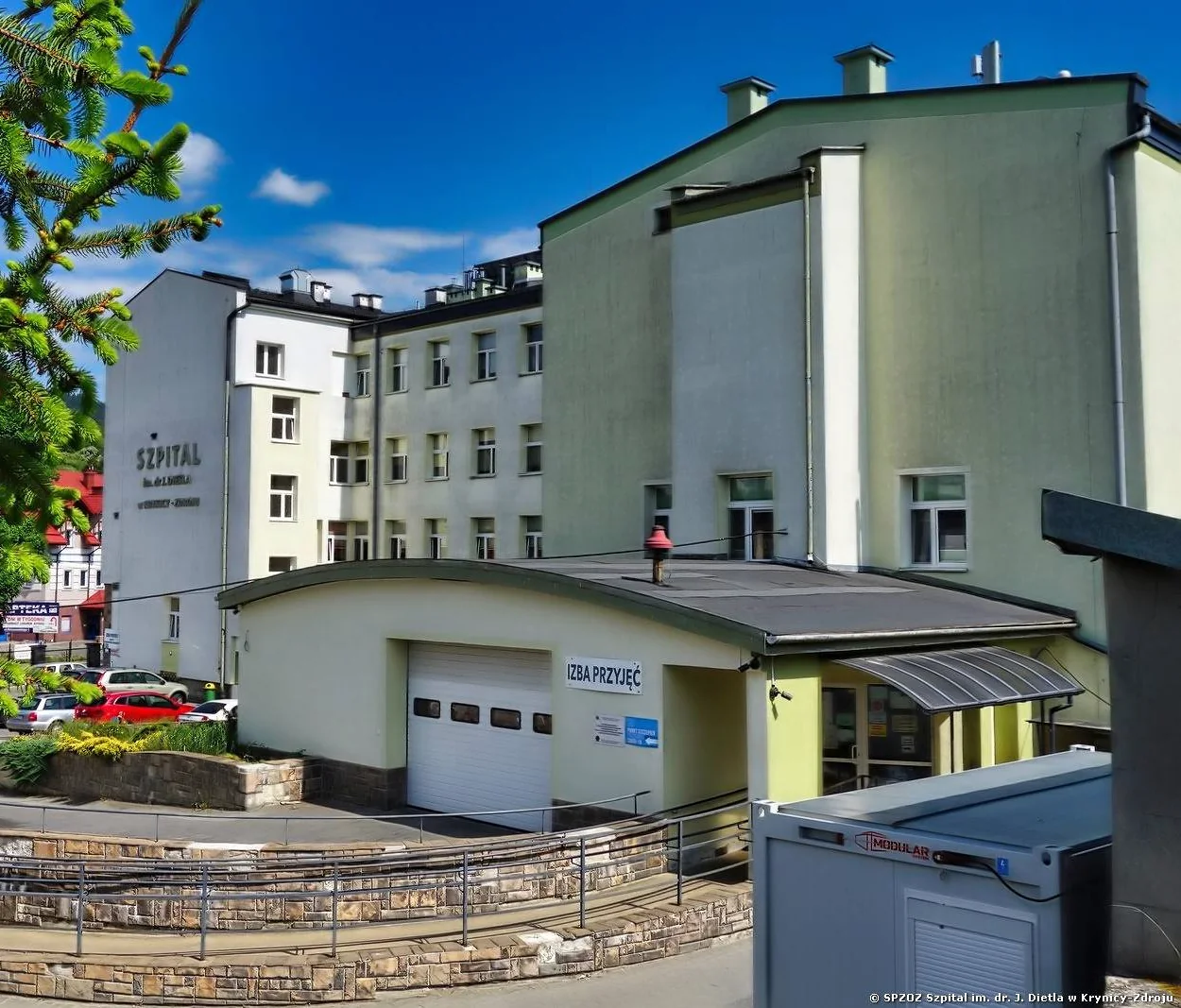 Budynek Szpitala im. dr. Józefa Dietla w Krynicy-Zdroju z jasną elewacją i podjazdem.
