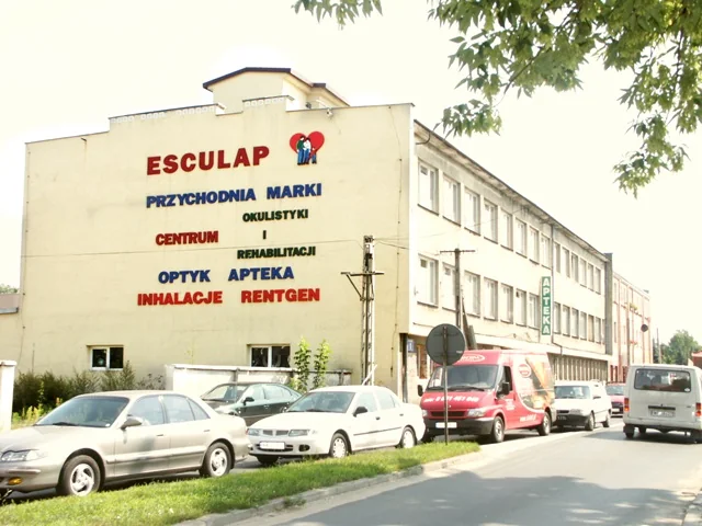 Budynek przychodni Esculap przy ul. Fabrycznej 1 w Markach, z szyldem placówki na jasnej elewacji.