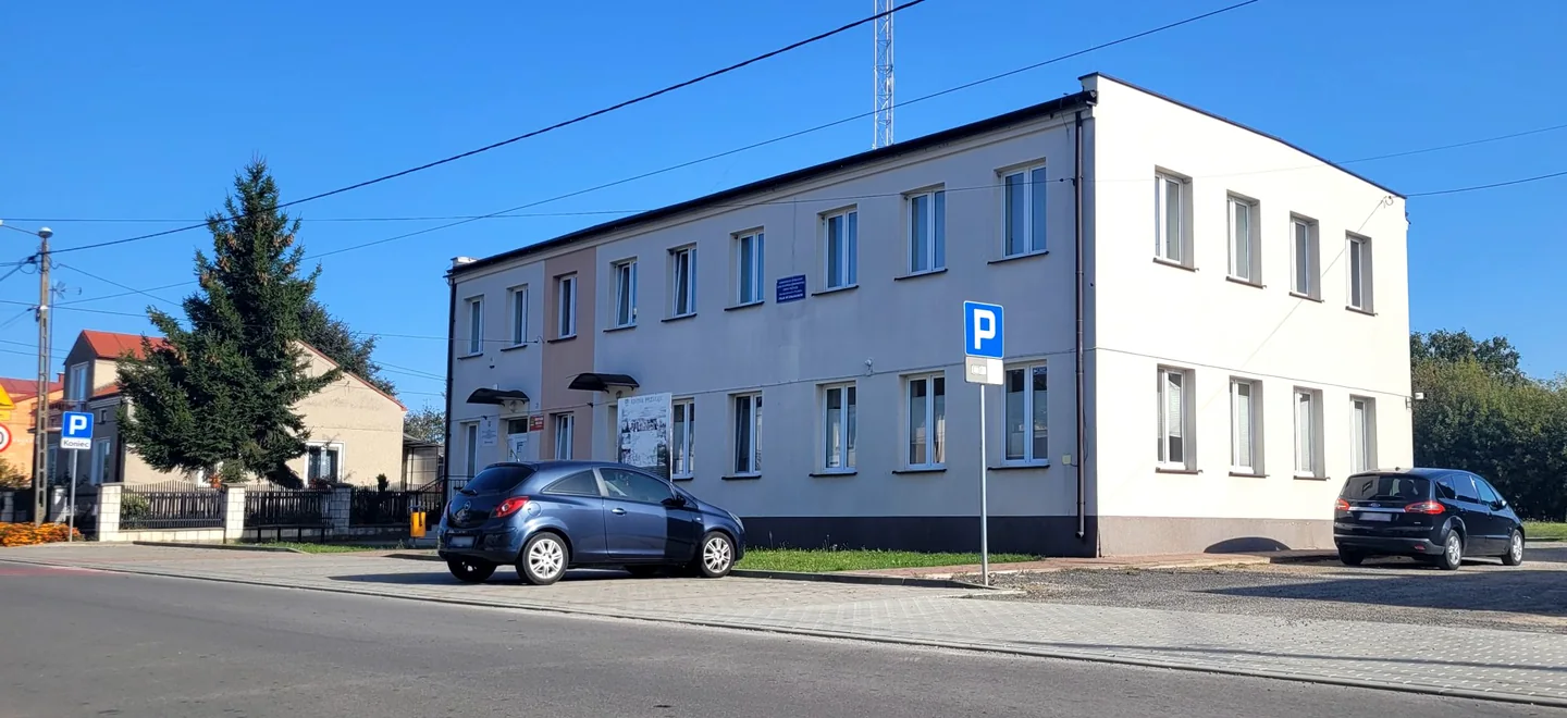 Jasny, piętrowy budynek przychodni SPZOZ w Załazach, z parkingiem przed wejściem.