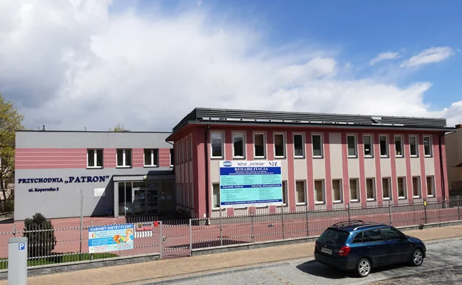 Budynek Przychodni Patron przy ulicy Kopernika w Kielcach, z ogrodzeniem od strony ulicy.