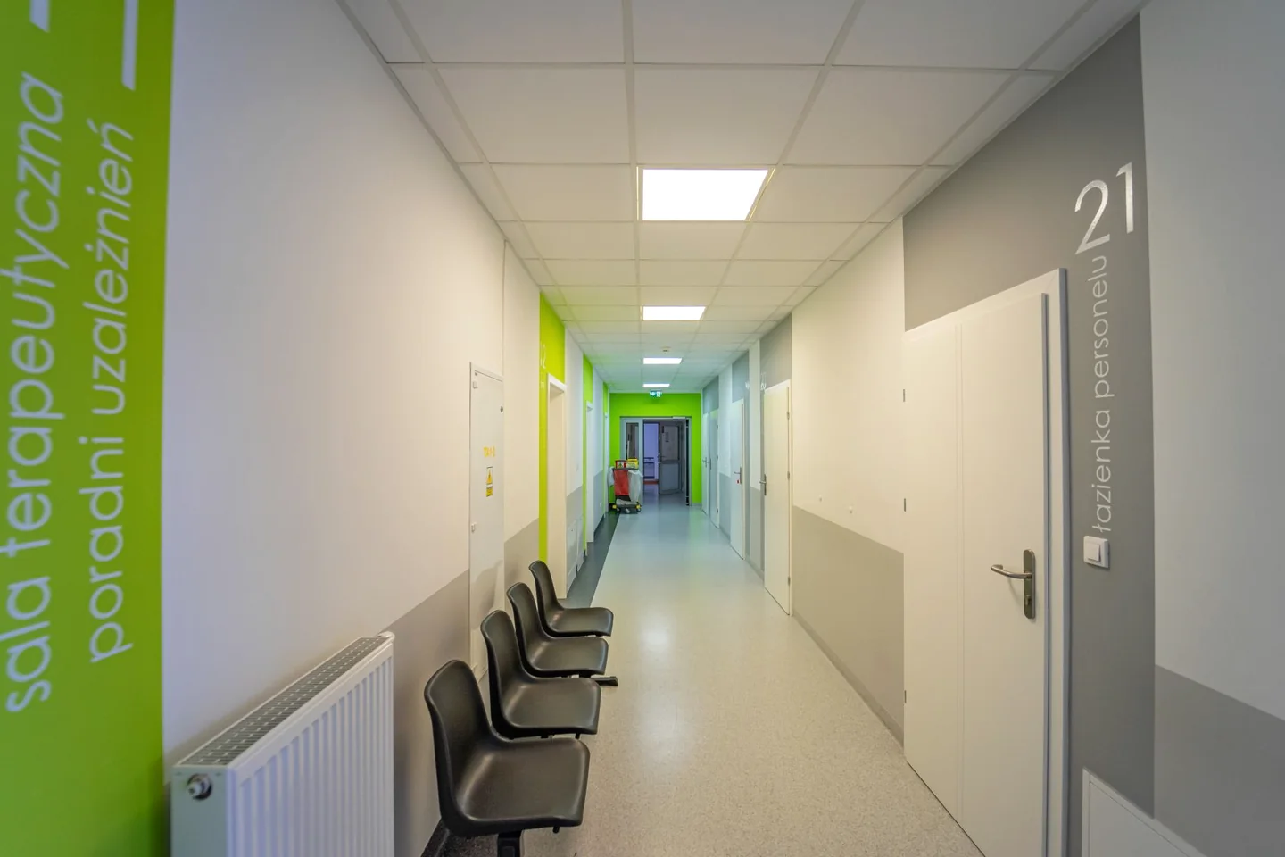 Korytarz poradni terapii uzależnień w Iławie, z krzesłami przy ścianie i wejściem do sali terapeutycznej.