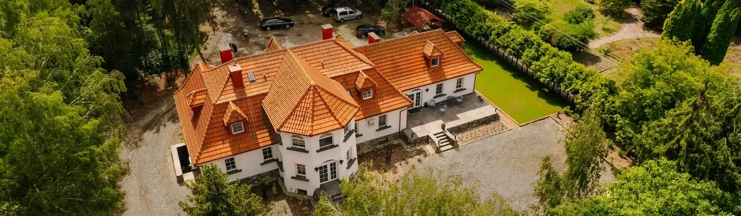 Budynek ośrodka EXIT w Licheniu Starym — widok z góry na pomarańczowy dach i otoczenie.