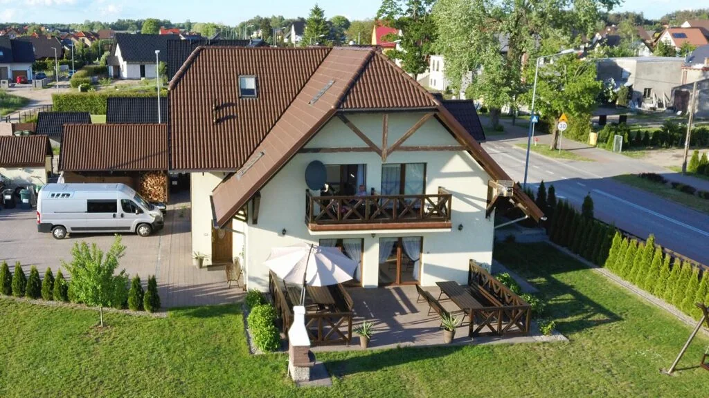 Budynek ośrodka Skrzydła w Rzepnicy z tarasem i ogrodem.