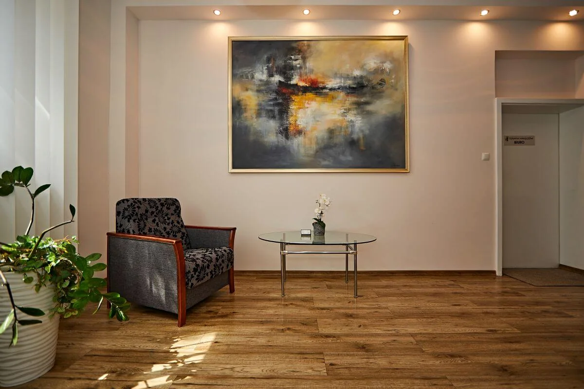 Wnętrze ośrodka Terapia Nałęczów w Uniszowicach z fotelem i stolikiem.